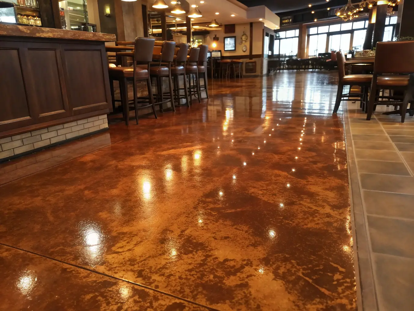 A wide shot of a metallic epoxy floor in a modern restaurant, featuring a seamless, reflective surface with subtle metallic accents. The floor complements the contemporary decor, creating a stylish and inviting dining experience.